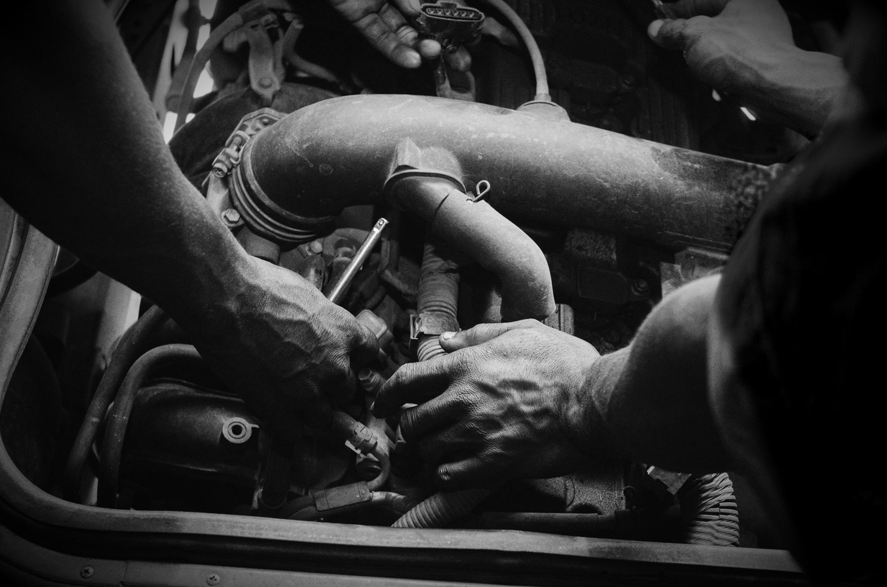 Mechanics' hands working on an engine