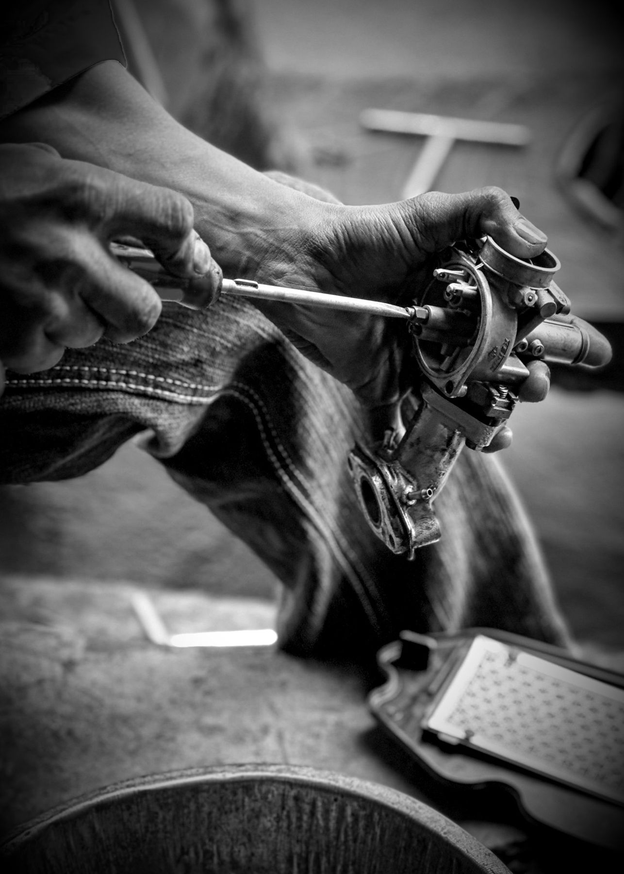 Mechanic's hands testing a part with a screwdriver